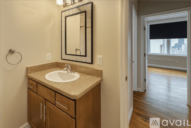 A bathroom with a sink, mirror, and wooden cabinets.