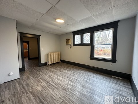 A room with a window and a door is available for rent.