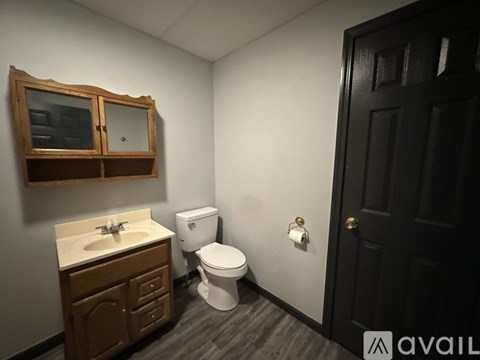A bathroom with a toilet, sink, and medicine cabinet.