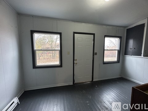 A room with a door, a window, and a wall heater.