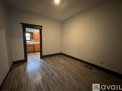 A room with wooden flooring and a large window.
