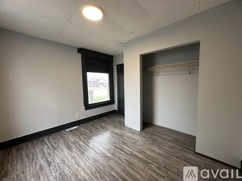 A room with a window and a closet.