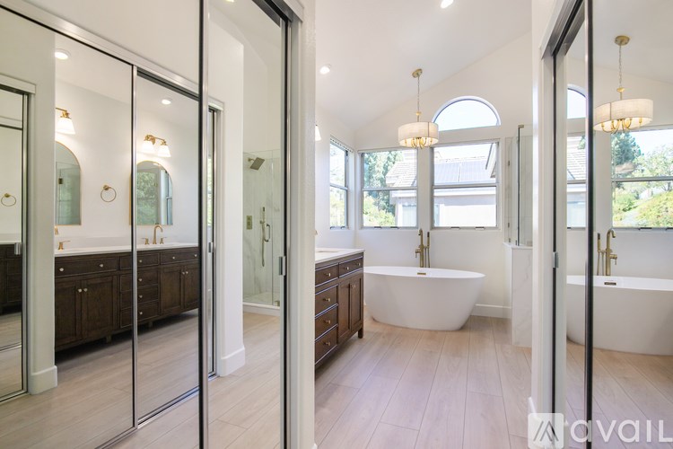 A modern bathroom with a large tub and double sinks.