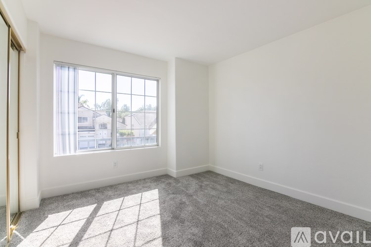 A room with a large window and carpeted floor.