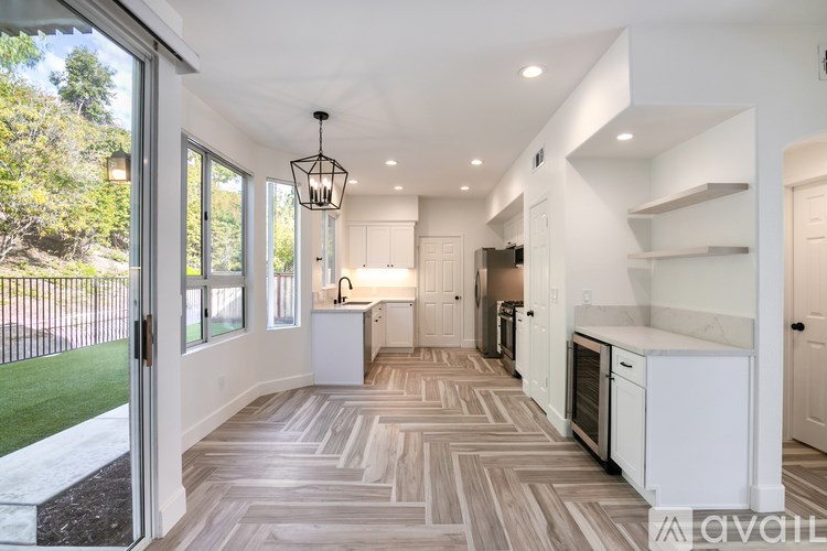 A modern kitchen with a large island and a dining area.
