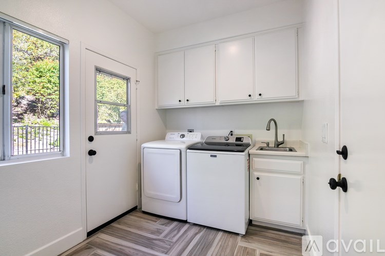 A small white kitchen with a washer and dryer.