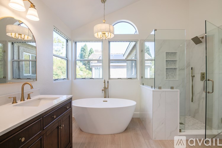 A bathroom with a white tub and a glass shower.