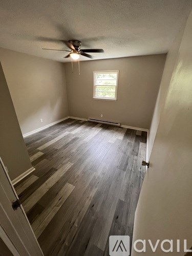 A room with wooden flooring and a window.