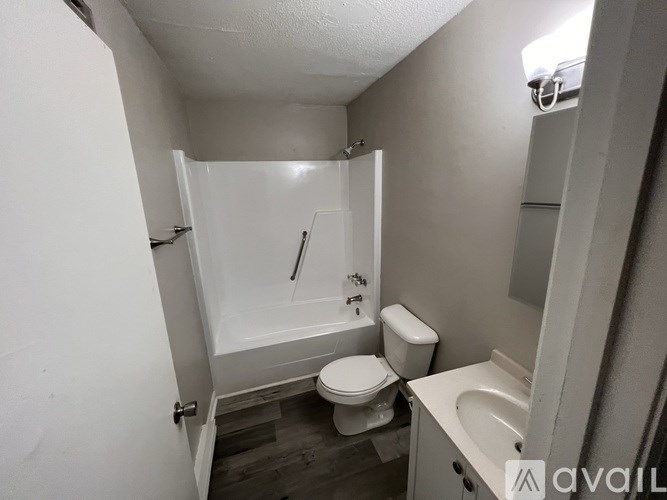 A small bathroom with a toilet, sink, and bathtub.