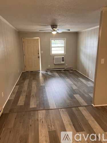 A room with wooden flooring and a ceiling fan.