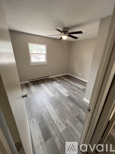 A room with a ceiling fan and a window.