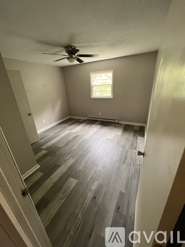 A room with a ceiling fan and a window.
