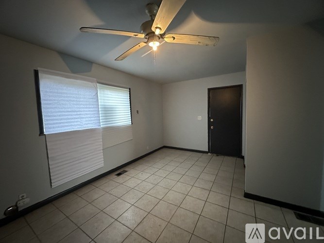 A room with a ceiling fan and a door.