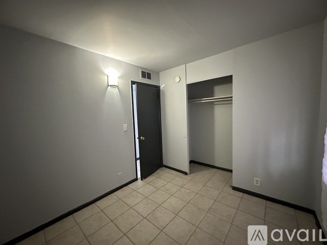 A room with a door and a mirror on the wall.