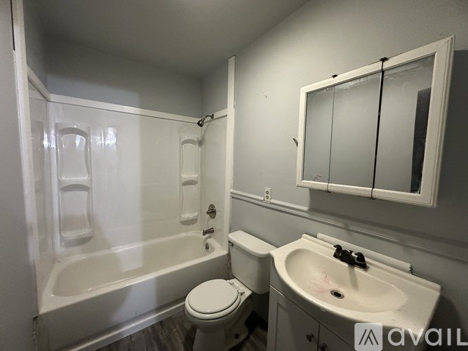 A white bathroom with a toilet, sink, and bathtub.