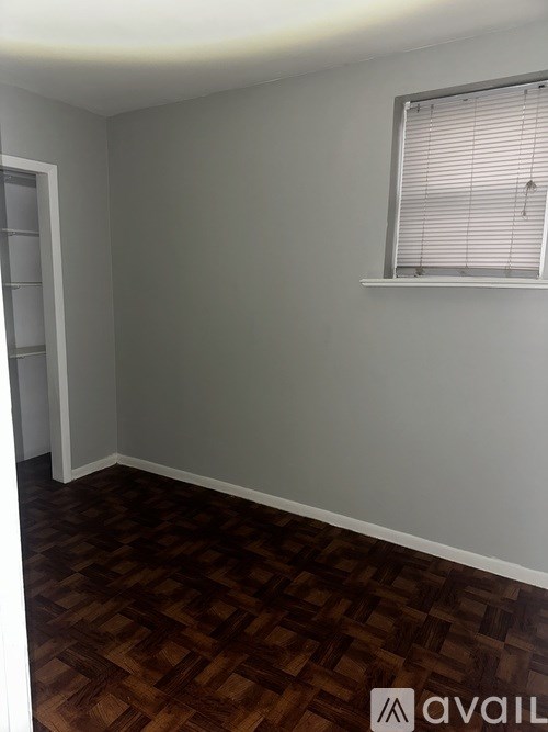 A room with a window and wooden flooring.