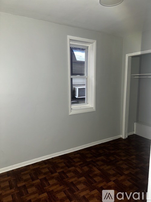 A room with a window and wooden flooring.