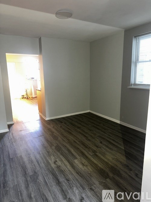A room with wooden flooring and white walls.