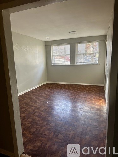 A room with wooden flooring and a window.