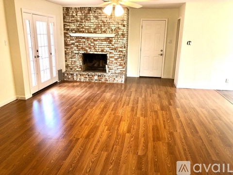 A room with a fireplace and wooden floors.