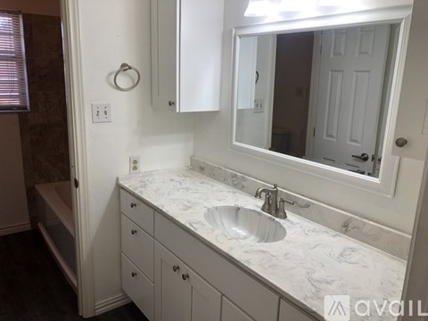 A bathroom with a marble countertop and a white sink.