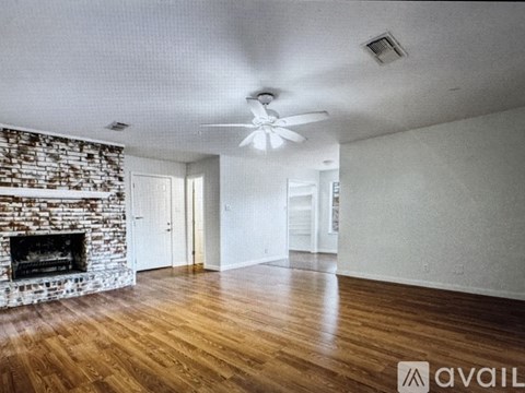 A living room with a fireplace and wood flooring.