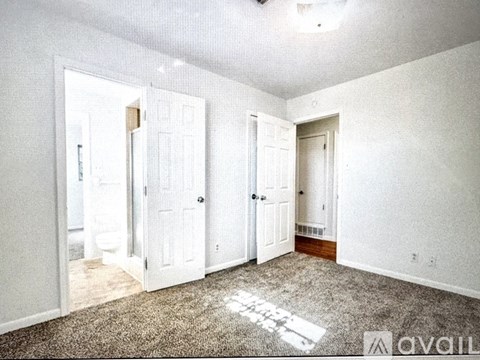 A room with white walls and a carpet that says "AVAIL" on it.
