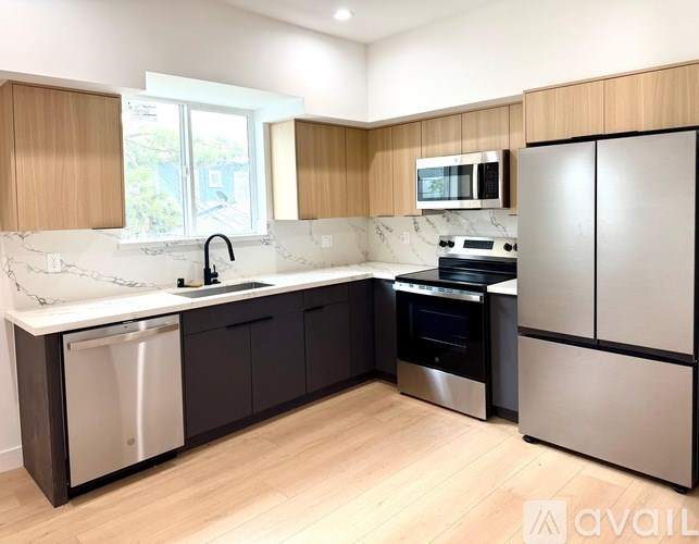 A kitchen with a sink, dishwasher, oven, and refrigerator.