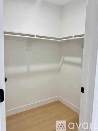 A white closet with a wooden floor and white walls.