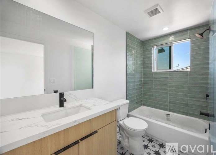 A bathroom with a marble countertop and a glass-enclosed shower.
