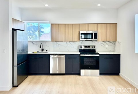 A modern kitchen with dark blue cabinets and stainless steel appliances.