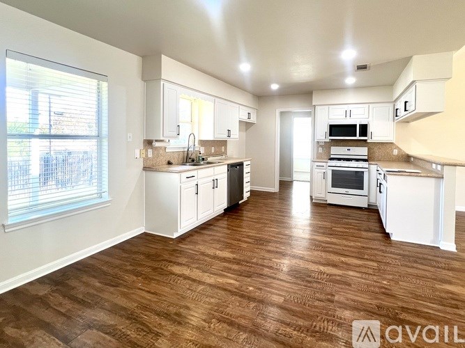 A room with a ceiling fan and wooden flooring.