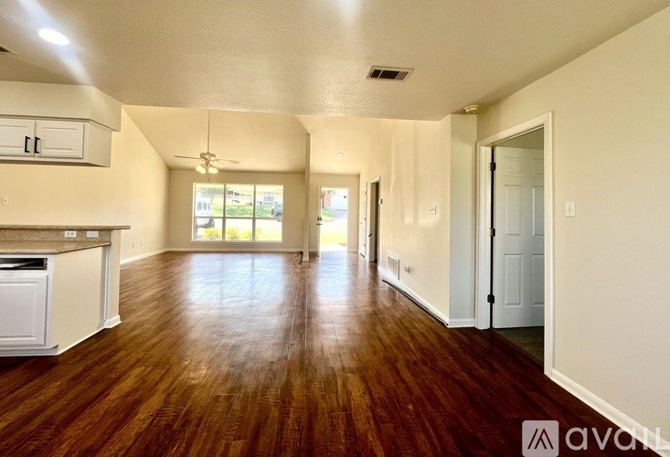 A kitchen with white cabinets and a wooden floor.