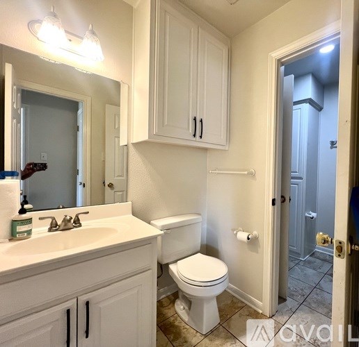 A room with a carpeted floor and a window with blinds.