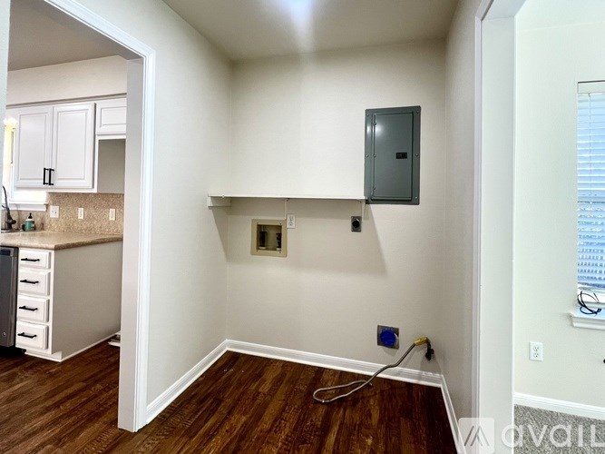 A room with a wood floor and a window with blinds.