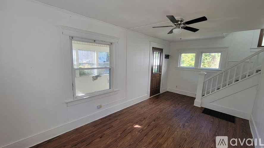 A room with wooden floors and a ceiling fan.