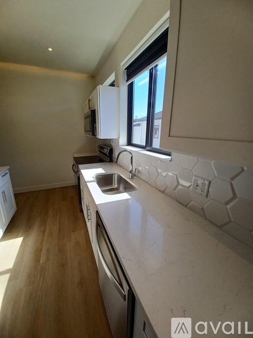 A kitchen with a white counter top and a window.