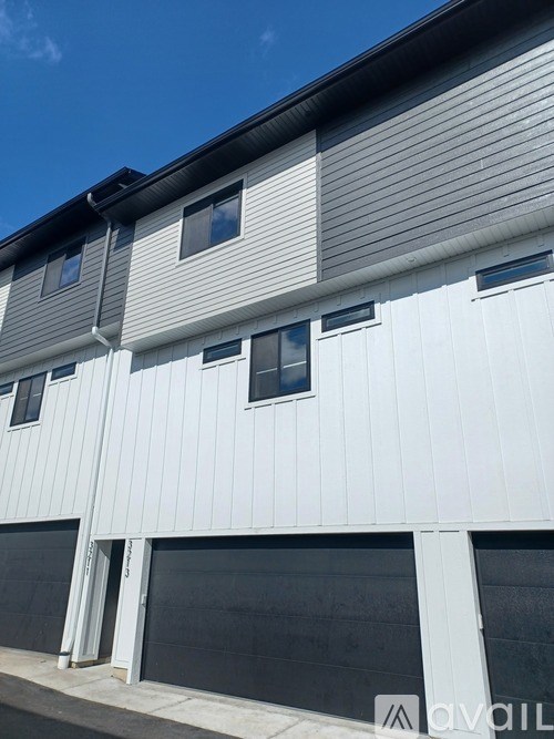 A modern building with a white facade and grey roof.