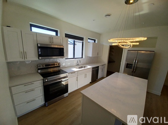 A kitchen with white cabinets and a large island.