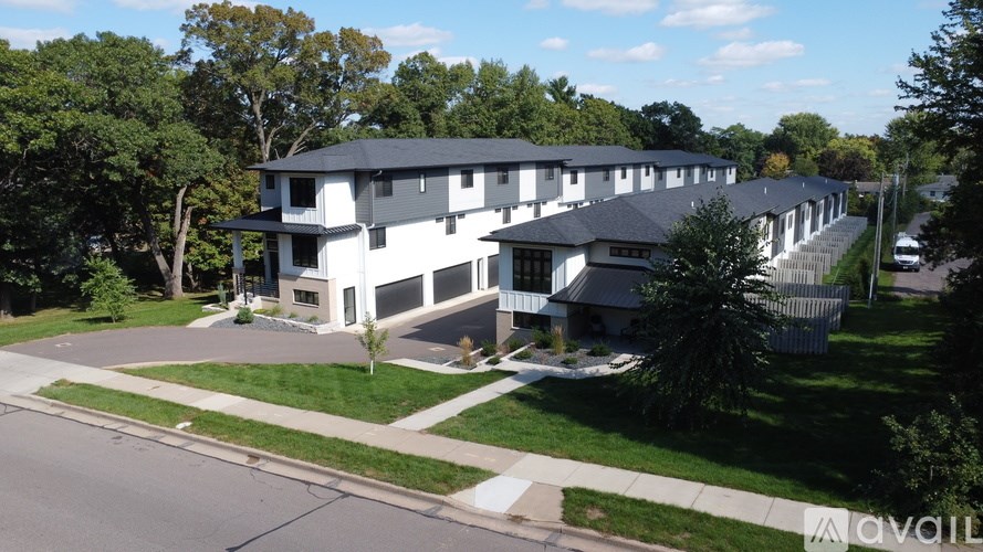 A row of houses with a car parked in front of the first house.
