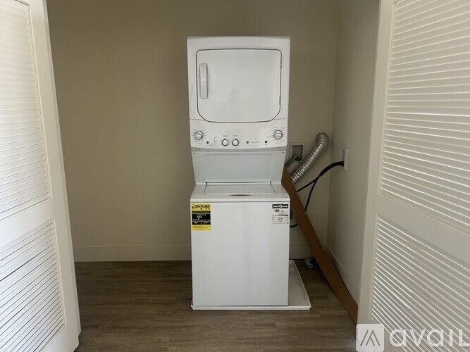 A white arcade machine sits in a corner of a room.