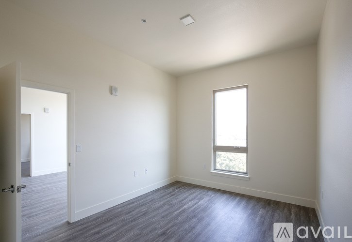 A room with a window and a door leading to another room.