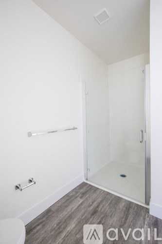 A bathroom with a toilet, a walk-in shower, and a towel bar.