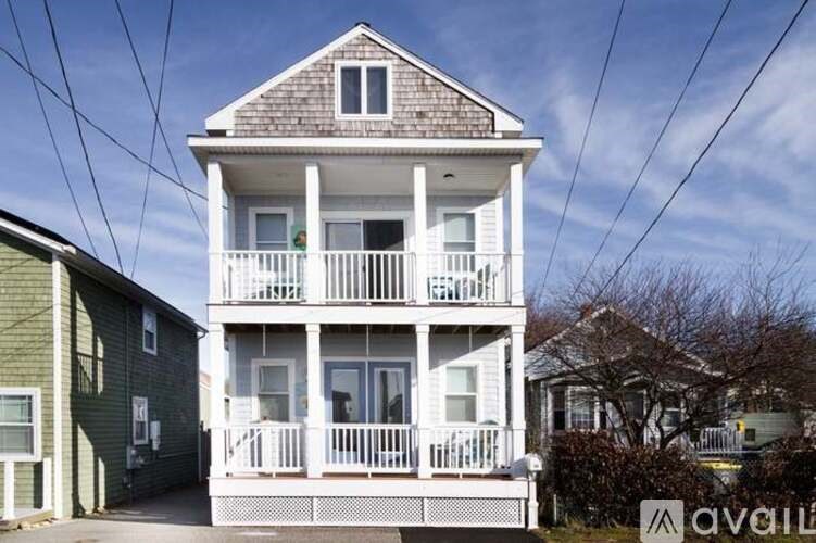 A two-story house with a balcony and a porch.