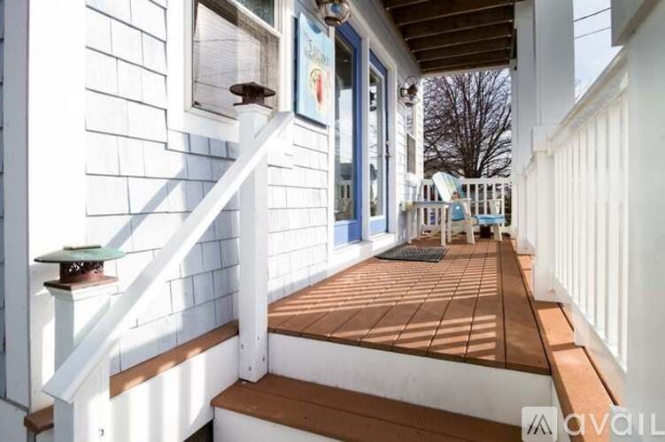 A wooden deck with a white railing and a painting hanging on the wall.
