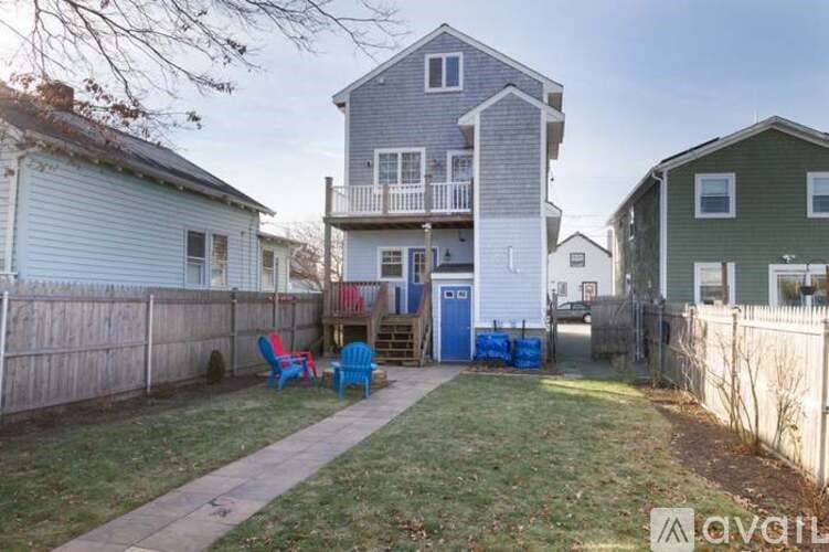 A backyard with a wooden fence and a blue chair.