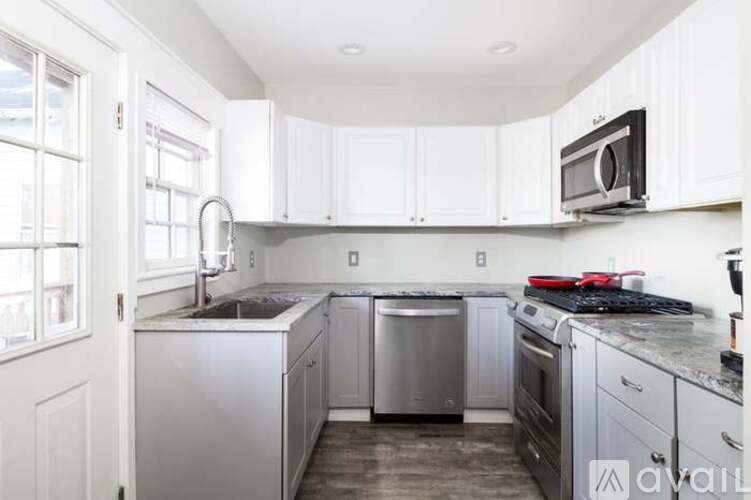 A kitchen with white cabinets and stainless steel appliances.
