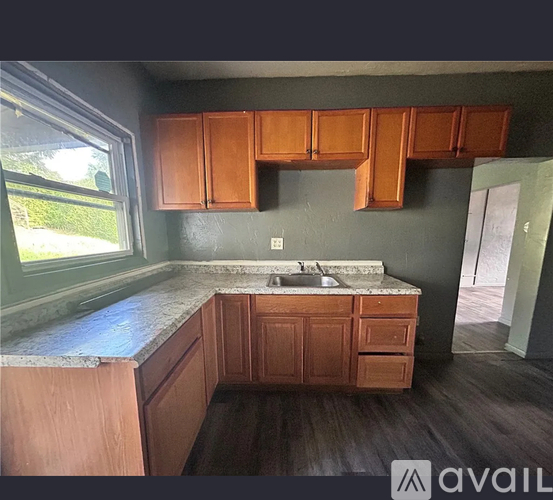 A kitchen with wooden cabinets and a marble countertop.