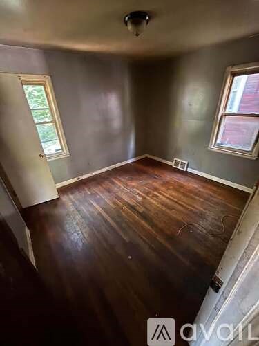 A room with a ceiling fan and wooden flooring.