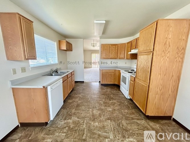 A kitchen with wooden cabinets and a countertop is available for rent.